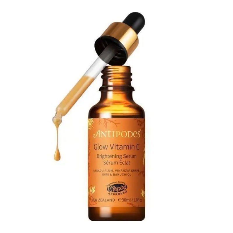 An amber glass dropper bottle of AntiPodes Glow Vitamin C Brightening Serum with a gold and black dropper, shown on a clean white background.