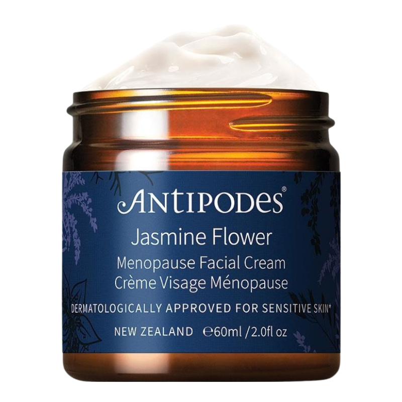 An open jar of Antipodes Jasmine Flower Menopause Facial Cream, showing a thick white cream product inside an amber glass jar with a navy blue label.