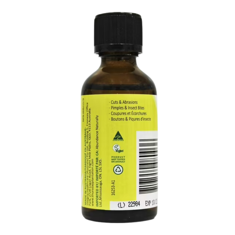 An amber glass bottle of natural balm with a black cap and a bright yellow label, shown from the back against a white background.